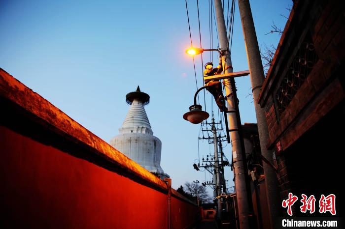 元旦前夕，北京城市照明管理中心員工檢修維護白塔寺等地區(qū)照明設施?！埑?攝