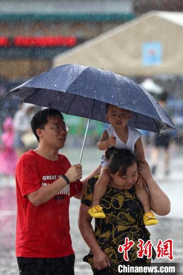 市民冒雨前行?！°蟛?攝