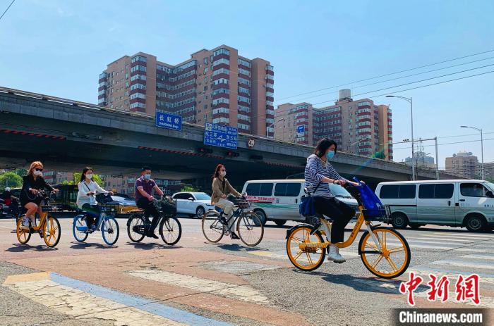 5日，北京東三環(huán)附近正騎單車出行的市民。