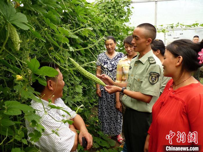 圖為官兵向民眾傳授蔬菜種植技術(shù)?！●R軍 攝