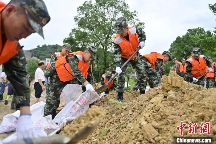 武警江西總隊機(jī)動支隊官兵奔赴江西景德鎮(zhèn)市樂平市開展搶險救援，填裝沙袋?！∨矶?攝