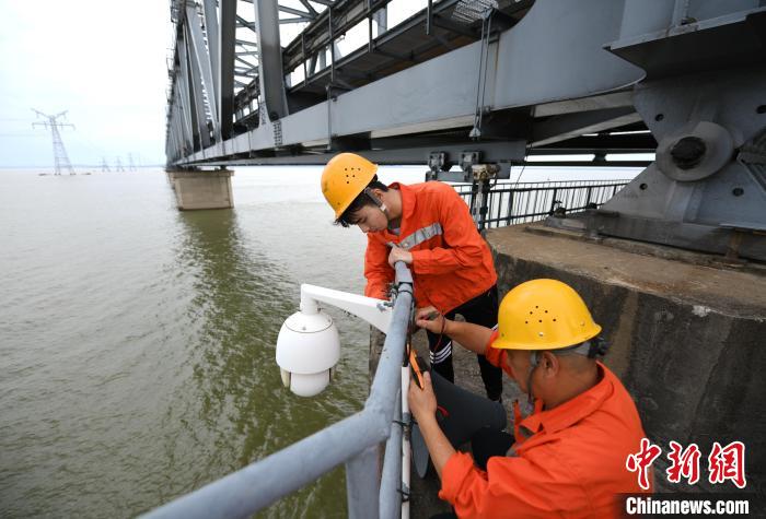 6月24日，南鐵九江橋工段的橋梁工正在九景衢鐵路鄱陽湖大橋上對監(jiān)控攝像頭進(jìn)行檢修?！『鷩?攝