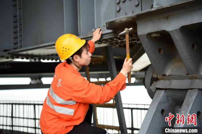 6月24日，南鐵九江橋工段的橋梁工正在九景衢鐵路鄱陽湖大橋上對高強(qiáng)度螺栓進(jìn)行檢查更換?！?黃旸 攝