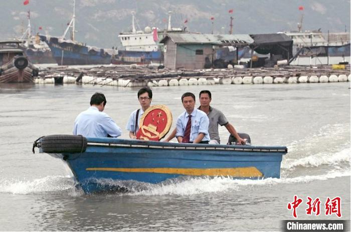 三都海上巡回法庭設(shè)立之初，法官們帶著國(guó)徽、坐著快艇，到漁排上審理、調(diào)解案件?！〗冻菂^(qū)法院 供圖