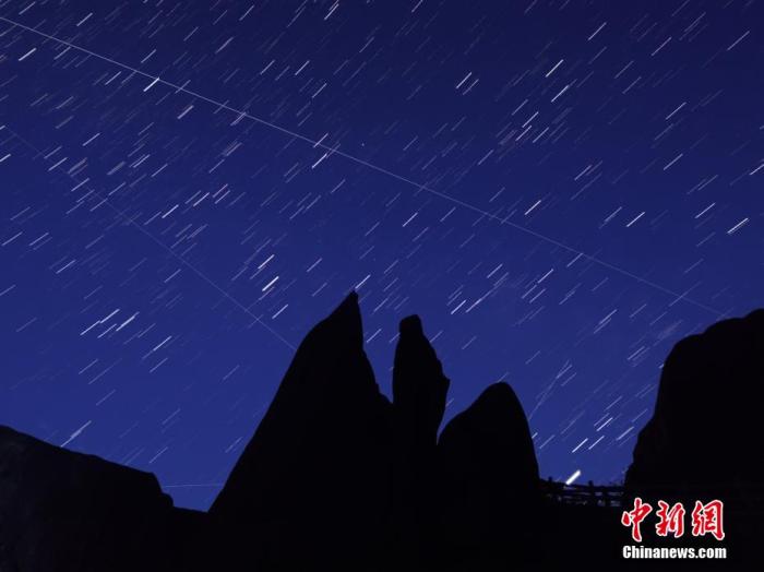 資料圖：北半球三大流星雨之一的英仙座流星雨現(xiàn)身夜空。在安徽黃山之巔，流星穿梭銀河交相輝映。星空璀璨，群山綿延，黃山之巔蔚然壯觀。梅建 攝