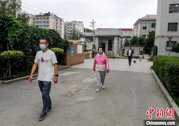 烏魯木齊市沙依巴克區(qū)國道社區(qū)，市民保持距離在小區(qū)內(nèi)散步?！＄娦?攝