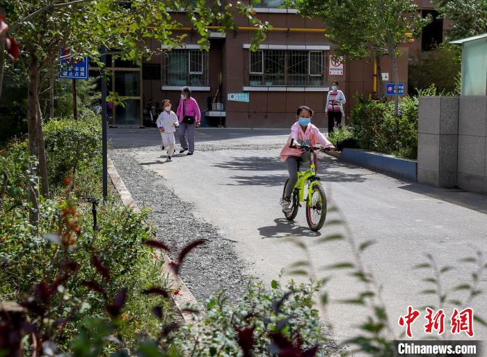 烏魯木齊市水磨溝區(qū)七道灣東街南社區(qū)，居民下樓在小區(qū)內(nèi)活動?！＄娦?攝