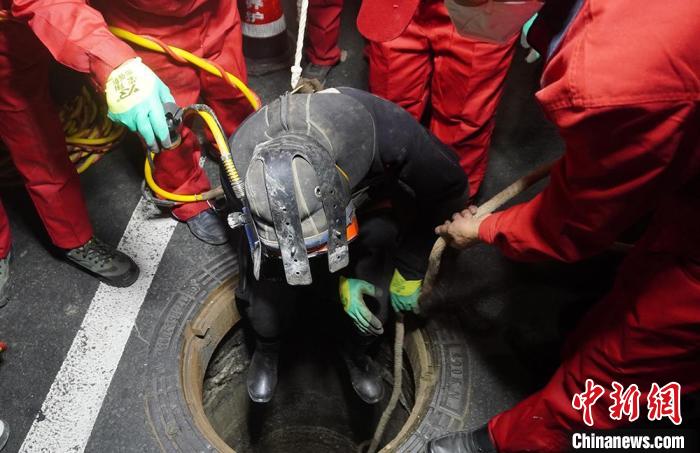 圖為“市政蛙人”穿著厚重的潛水服，潛入污水管道內對堵塞管道進行疏通。　九美旦增 攝