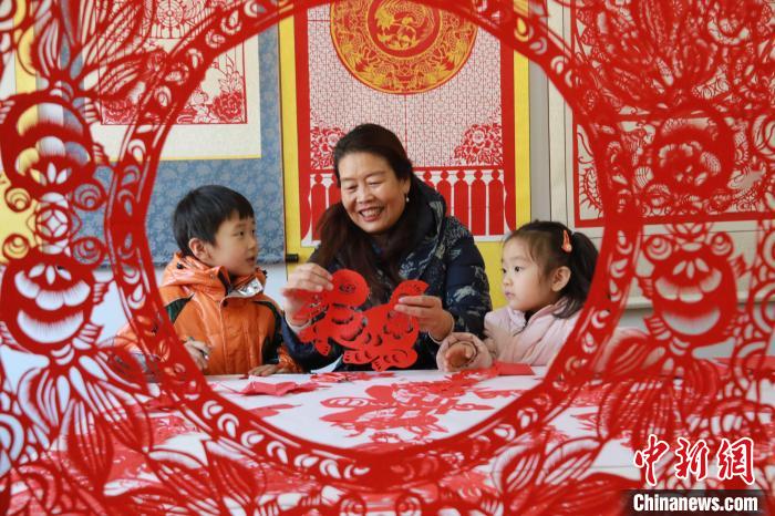 非遺傳承人田桂芹在帶領(lǐng)孩子們進(jìn)行迎新年剪紙創(chuàng)作?！±詈?攝