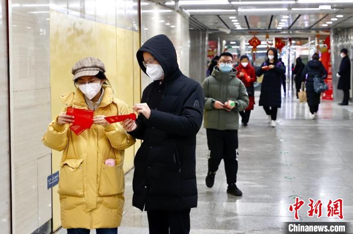 北京市朝陽(yáng)區(qū)聯(lián)動(dòng)京港地鐵在14號(hào)線九龍山站站廳內(nèi)為地鐵乘客派發(fā)“拜年紅包”。　<a target='_blank' href='/'>中新社</a>記者 富田 攝