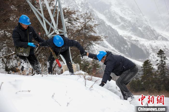 西藏波密縣電力巡護(hù)人員相互幫助，趟雪踏冰。　李東淮 攝