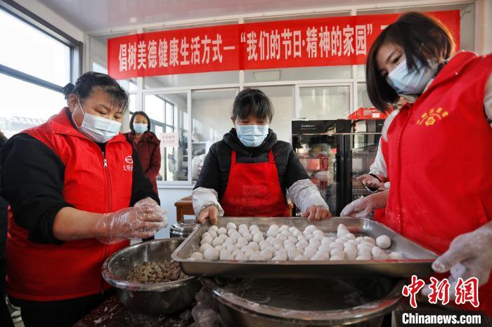 在泰安市泰山區(qū)邱家店鎮(zhèn)王林坡村的幸福食堂，眾多志愿者帶領(lǐng)村里的庫區(qū)移民包元宵?！￡愱?攝