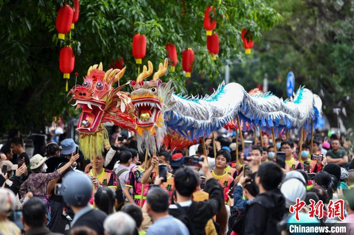 圖為“裝馬匹”民俗巡游隊(duì)伍中的舞龍方陣，吸引民眾圍觀?！●樤骑w 攝