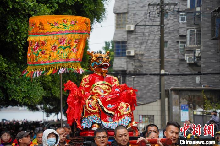 圖為巡游隊(duì)伍抬著龍王塑像在街上巡游?！№f國(guó)政 攝