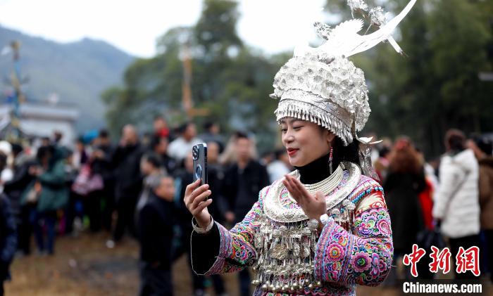 一名苗族姑娘在古龍坡會(huì)上直播?！●麘c和 　攝