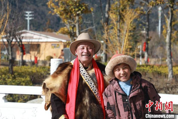 圖為林芝市巴宜區(qū)布久鄉(xiāng)仲果村村民桑杰與孫子一起參加藏歷新年活動(dòng)?！埩?攝