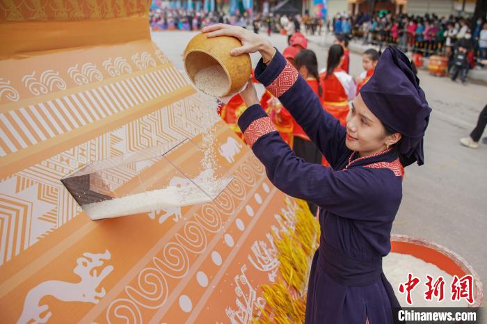 圖為民眾將稻米倒入谷倉(cāng)，寓意五谷豐登、糧倉(cāng)滿滿?！￡惞谘?攝