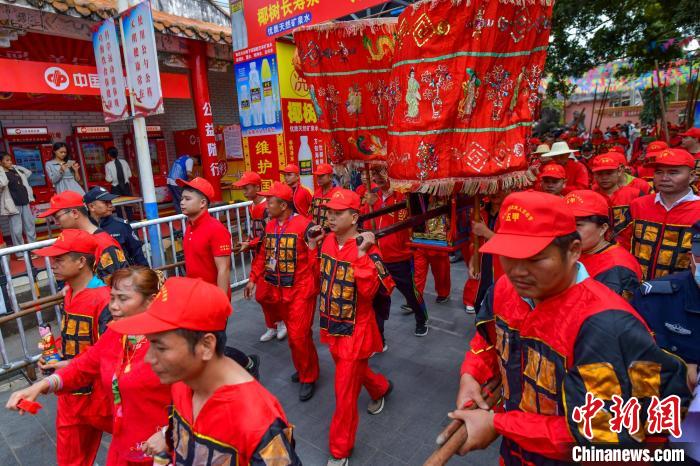 圖為眾人抬著冼夫人的“神輿”，走在“裝軍巡游”隊伍中。　駱云飛 攝