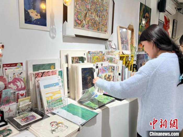 圖為藝術(shù)品商店內(nèi)，顧客挑選插畫作品。　鐘旖 攝