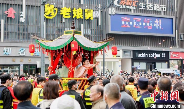 蠶花姑娘將寓意祝福的蠶花、糖果拋向民眾 新市鎮(zhèn)供圖