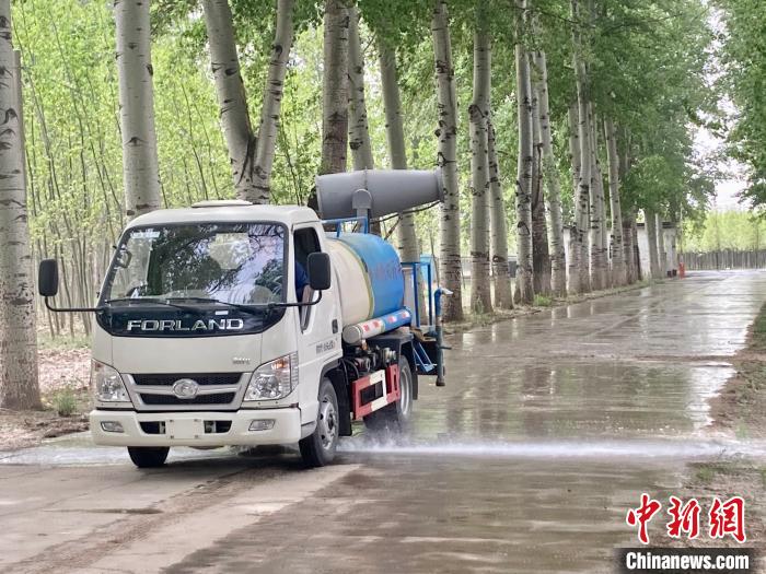 圖為灑水車在對地面進(jìn)行濕化，降低飄絮強(qiáng)度?！⌒戽?攝