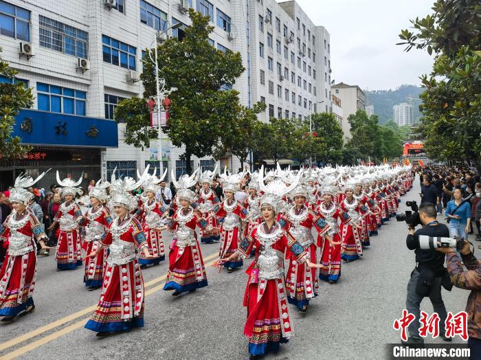 上百名美麗的姑娘著節(jié)日盛裝與蘆笙隊(duì)伍進(jìn)行巡游?！「毒窜?攝