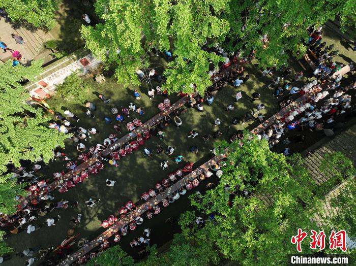 5月26日，人們在貴州黃平縣飛云崖景區(qū)體驗(yàn)長桌宴，歡度節(jié)日“四月八”?！×何?攝