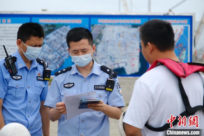 平潭邊檢站移民管理警察對船員證件進(jìn)行查驗?！±钭谒?攝