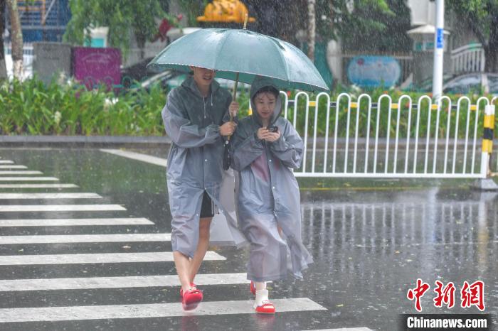 圖為海口市民冒雨出行。　駱云飛 攝