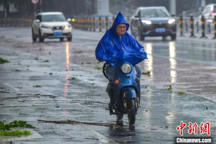 圖為海口市民冒雨出行。　駱云飛 攝