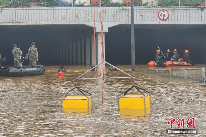 韓國救援人員沿著一條被洪水淹沒的道路搜尋失蹤人員，這條道路通往被洪水淹沒的地下隧道。視覺中國