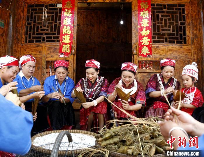 施秉縣楊柳塘鎮(zhèn)板屯村陸地坪苗寨苗族女同胞們圍坐一起包粽粑，共慶“六月六”粽粑節(jié)?！》盍?攝